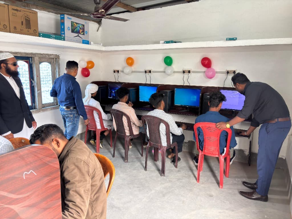 Instructor assisting students hands-on with computer software exercises
